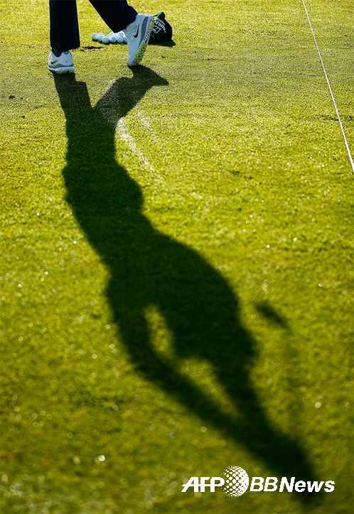 타이거 우즈가 골프 스윙을 연습하는 장면을 그림자로 포착한 모습이다. 사진제공=ⓒAFPBBNews = News1